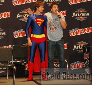 John's husband, Scott Gill enters the stage as Superman. 